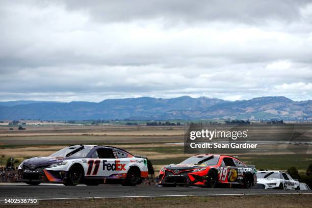Denny Hamlin, driver of the FedEx Freight Toyota, and Martin Truex Jr., driver of the Bass Pro Shops Toyota, race during the NASCAR Cup Series...