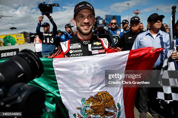 Daniel Suarez, driver of the Onx Homes/Renu Chevrolet, celebrates with a Mexican flag after winning the NASCAR Cup Series Toyota/Save Mart 350 at...