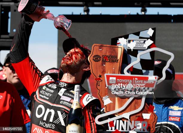 Daniel Suarez, driver of the Onx Homes/Renu Chevrolet, celebrates by pouring wine on himself in victory lane after winning the NASCAR Cup Series...