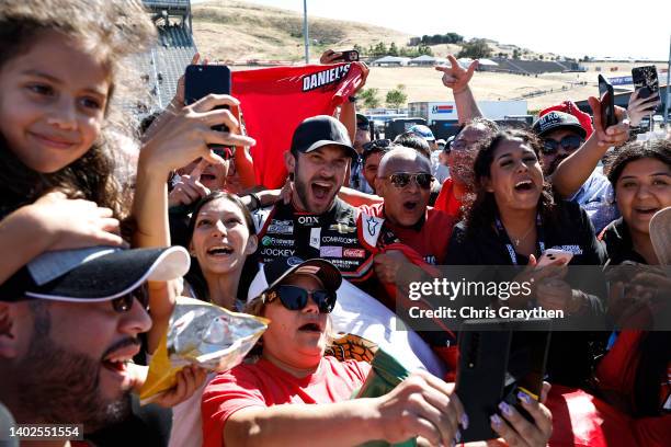 Daniel Suarez, driver of the Onx Homes/Renu Chevrolet, celebrates with Daniel's Amigos after winning the NASCAR Cup Series Toyota/Save Mart 350 at...