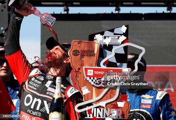 Daniel Suarez, driver of the Onx Homes/Renu Chevrolet, celebrates by pouring wine on himself in victory lane after winning the NASCAR Cup Series...