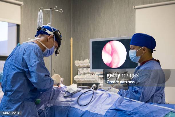 two surgeons working together in the theatre - micro surgery stock pictures, royalty-free photos & images