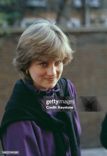 British Royal Lady Diana Spencer , wearing a black sweater draped over the shoulders of a purple blouse, as she leaves the Young England kindergarten...