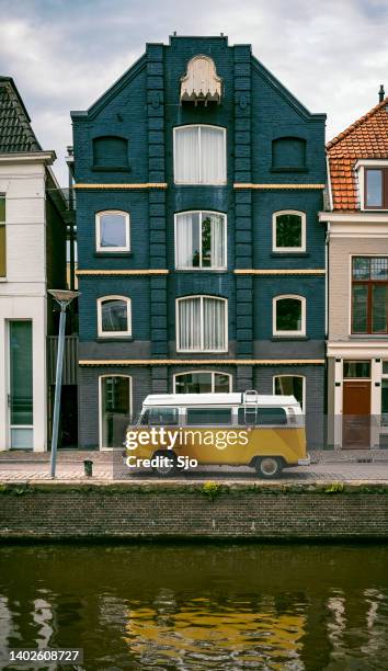 volkwasgen bus campervan em amarelo brilhante estacionado na cidade - sjoerd van der wal or sjo - fotografias e filmes do acervo