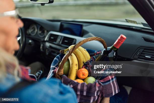 close up of a woman with full picnic basket in a car. - wine basket stock pictures, royalty-free photos & images