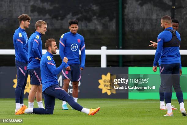 Harry Kane and Kyle Walker of England play rock paper scissors during a training session at The Sir Jack Hayward Training Ground on June 13, 2022 in...