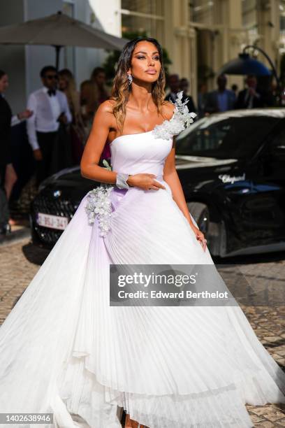 Madalina Ghenea wears diamonds pendant earrings, a pale purple white asymmetric shoulder with embroidered rhinestones and tulle details short dress...