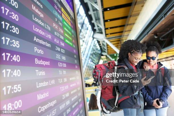 two young backpacking women at airport - geneve airport stock pictures, royalty-free photos & images
