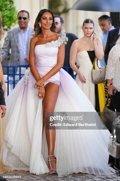 Madalina Ghenea wears diamonds pendant earrings, a pale purple white asymmetric shoulder with embroidered rhinestones and tulle details short dress...