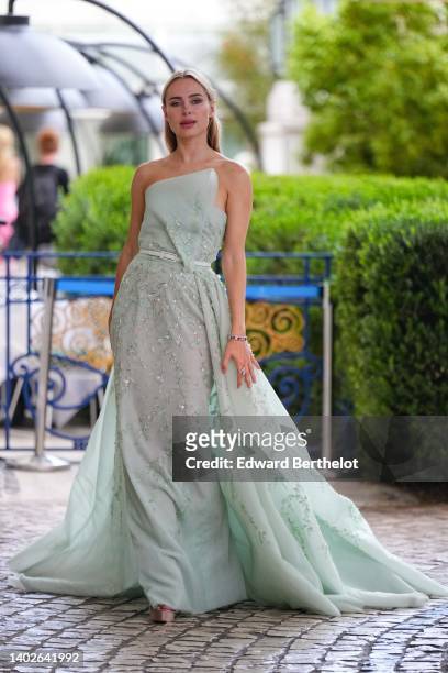 Kimberley Garner wears a pale green tulle with embroidered sequined asymmetric shoulder-off long ruffle dress, a white shiny leather small belt, a...