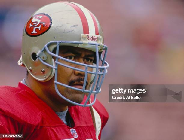 Jesse Sapolu, Center and Offensive Guard for the San Francisco 49ers looks out from behind his helmet face guard during the National Football...