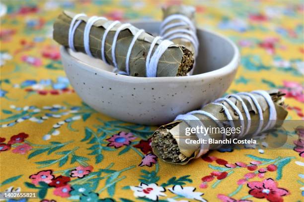 aromatic herbs rolled in bay leaves in a bowl - bay leaf stock-fotos und bilder