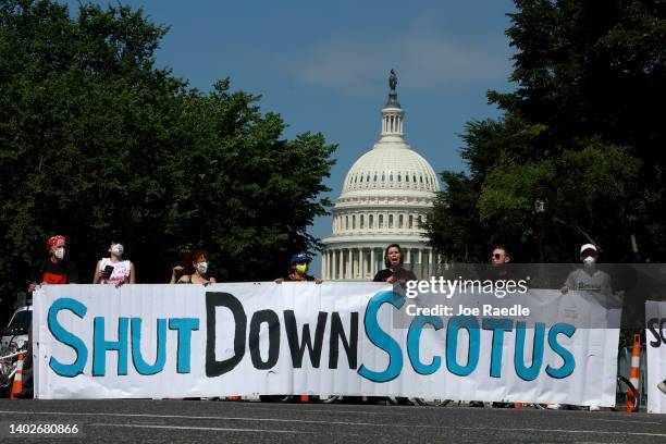Protesters hold a banner near the U.S. Supreme Court on June 13, 2022 in Washington, DC. The court continues to release opinions as the country...
