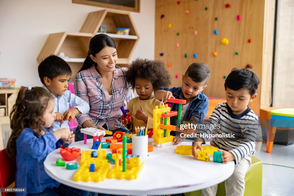 Teacher with a group of elementary students playing with toy blocks