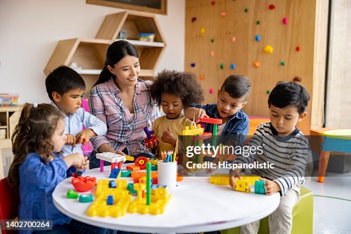 Teacher with a group of elementary students playing with toy blocks Teacher with a group of elementary students playing with toy blocks