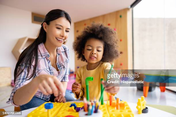 happy teacher playing with a girl in the classroom - preschool age bildbanksfoton och bilder