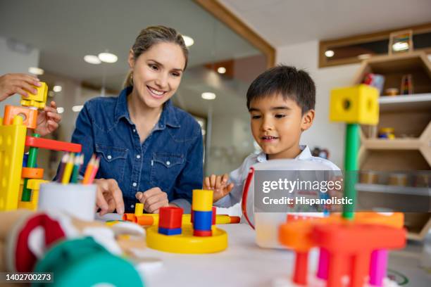 escolar jugando con bloques de construcción en el aula - salud ocupacional fotografías e imágenes de stock