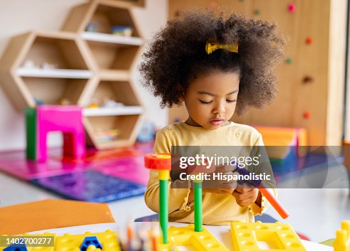 Ragazza afroamericana che gioca con i mattoni a scuola Ragazza afroamericana che gioca con i mattoni a scuola