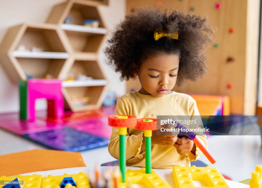 African American girl playing with building blocks at the school