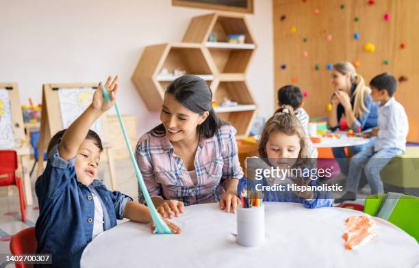 niños felices jugando con limo en la escuela y mostrando al maestro - limoso fotografías e imágenes de stock