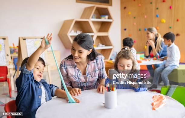 happy kids playing with slime at the school and showing the teacher - slimy stock pictures, royalty-free photos & images