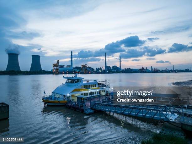 a ferry terminal on the huangpu river,the background is a thermal power generation. - fähre gas stock-fotos und bilder