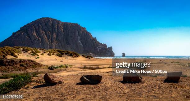 scenic view of beach against clear blue sky,morro bay,california,united states,usa - klippe stock-fotos und bilder