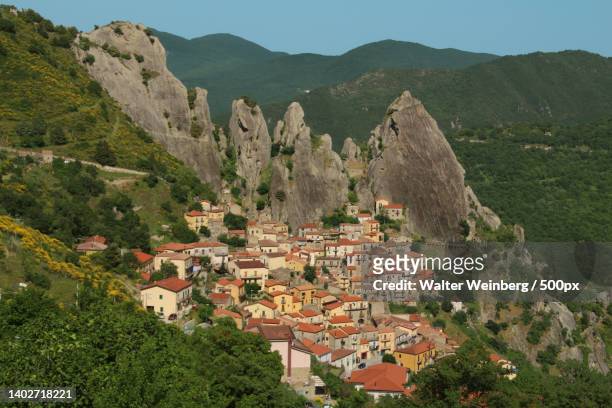 high angle view of townscape and mountains against sky,castelmezzano,potenza,italy - potenza stock pictures, royalty-free photos & images
