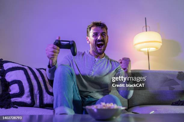 cheering while playing the game battle on the playstation - joystick stock pictures, royalty-free photos & images