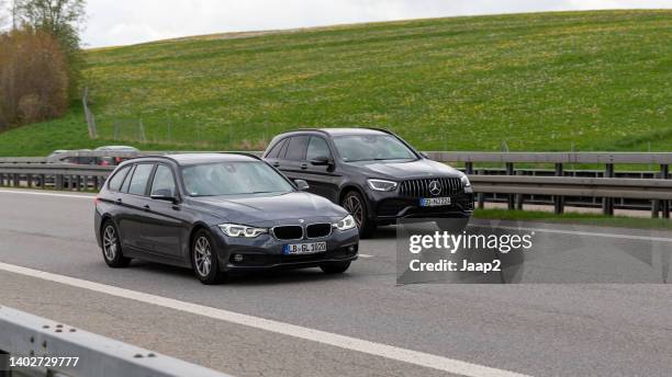 mercedes benz glc überholt bmw 3er auf der autobahn a7 - parallel stock-fotos und bilder