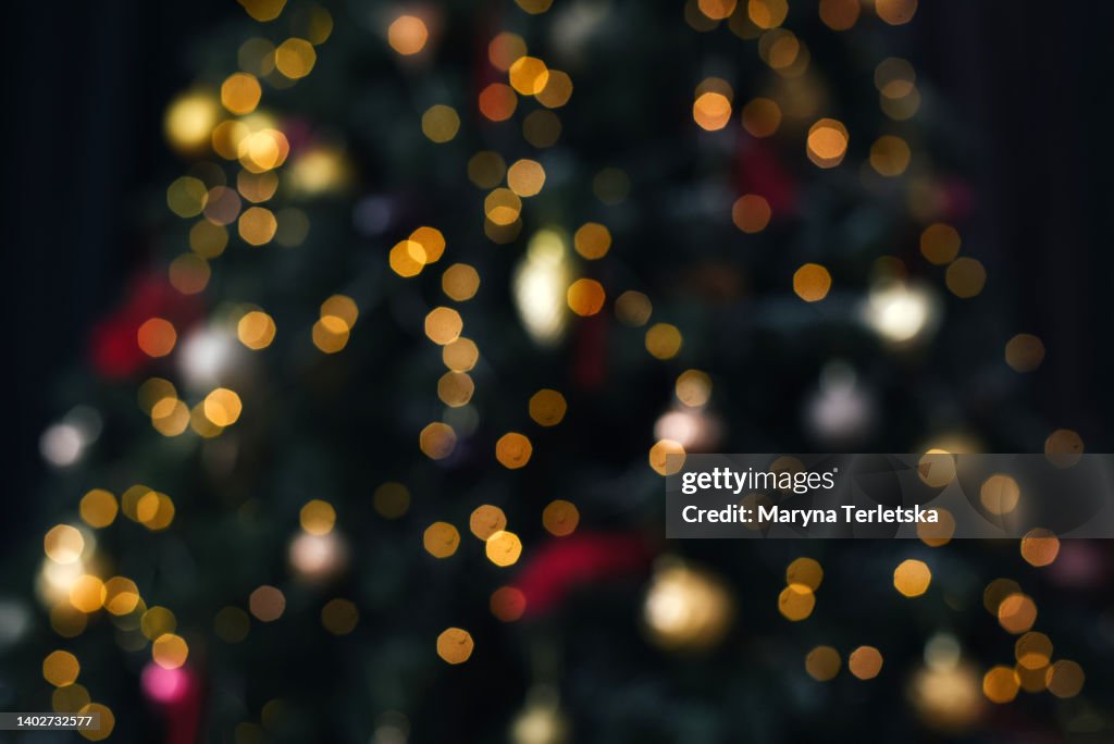Blurred defocus christmas background. Blurred dark background with Christmas tree. New Year. Christmas. Christmas decor. Christmas tree. Christmas background. Holiday.