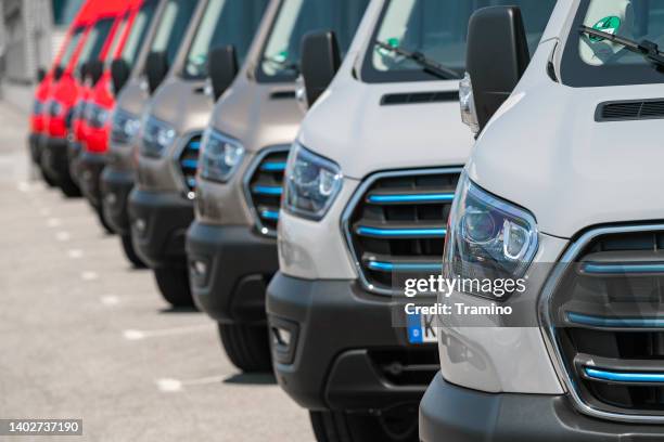electric delivery vans parked on a parking - veículo terrestre comercial imagens e fotografias de stock