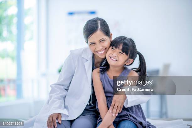 doctora y joven abrazando - oriental asiático e indio fotografías e imágenes de stock