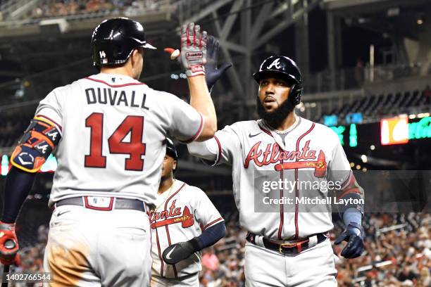 Marcell Ozuna of the Atlanta Braves celebrates with Adam Duvall after hitting a two-run homerun in the third inning during a baseball game against...