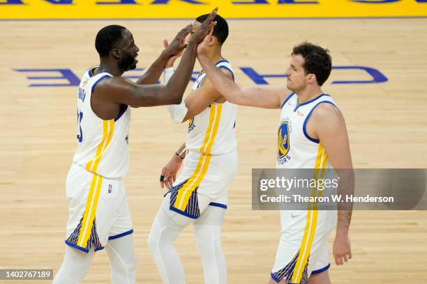 Draymond Green celebrates a play with teammates Jordan Poole and Nemanja Bjelica of the Golden State Warriors during the second quarter against the...