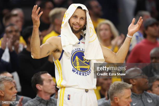 Stephen Curry of the Golden State Warriors reacts after teammate Draymond Green shot a free throw during the second quarter against the Boston...