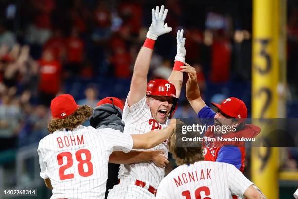 Rhys Hoskins of the Philadelphia Phillies celebrates with teammates after hitting a walk-off RBI double to defeat the Miami Marlins 3-2 at Citizens...