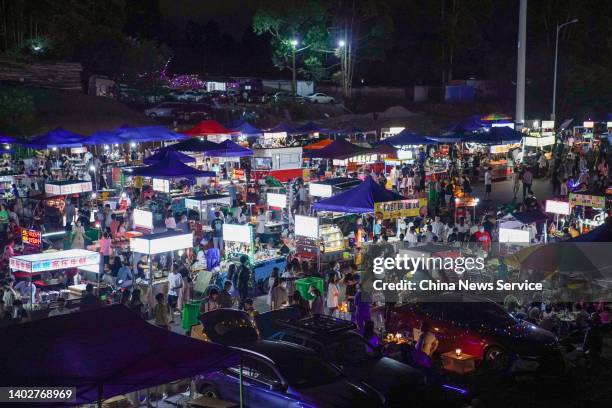 People enjoy food at a night fair on June 13, 2022 in Nanning, Guangxi Zhuang Autonomous Region of China.