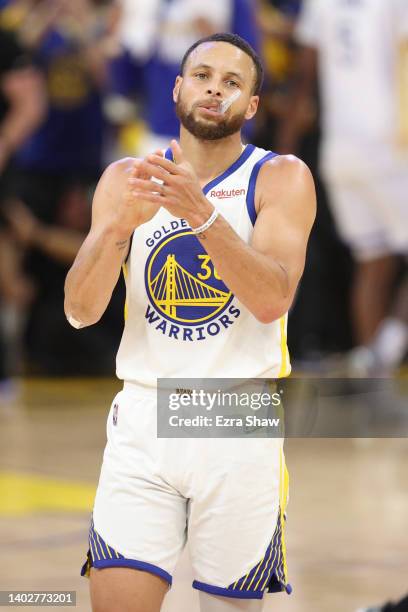 Stephen Curry of the Golden State Warriors celebrates a three point basket by teammate Jordan Poole during the third quarter against the Boston...