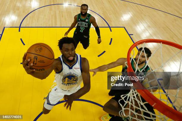 Andrew Wiggins of the Golden State Warriors drives to the basket against Jaylen Brown and Jayson Tatum of the Boston Celtics during the first half in...