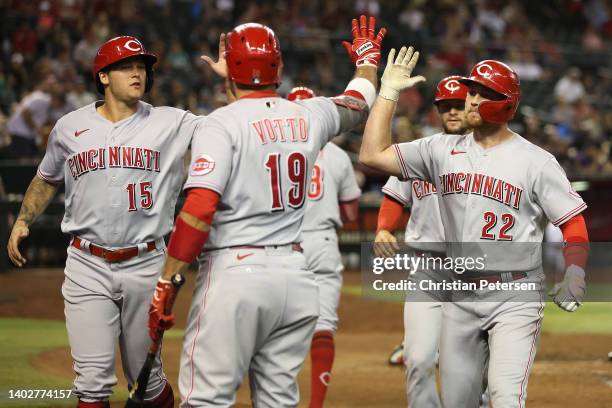 Brandon Drury of the Cincinnati Reds high fives Joey Votto and Nick Senzel after hitting a three-run home run against the Arizona Diamondbacks during...