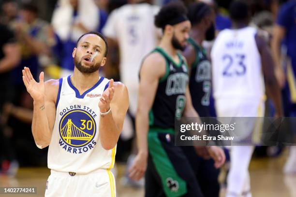 Stephen Curry of the Golden State Warriors celebrates a three point basket by teammate Jordan Poole during the third quarter against the Boston...