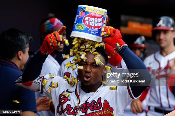 Ozzie Albies of the Atlanta Braves reacts as he has a bucket of dubble bubble gum dumped on his head following a grand slam during the seventh inning...