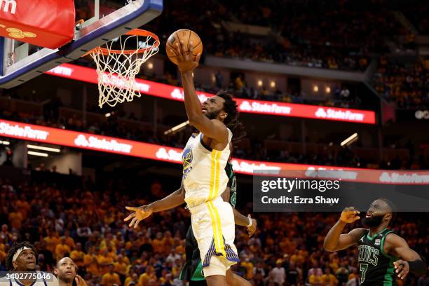 Andrew Wiggins of the Golden State Warriors drives to the basket against Robert Williams III and Jaylen Brown of the Boston Celtics during the fourth...