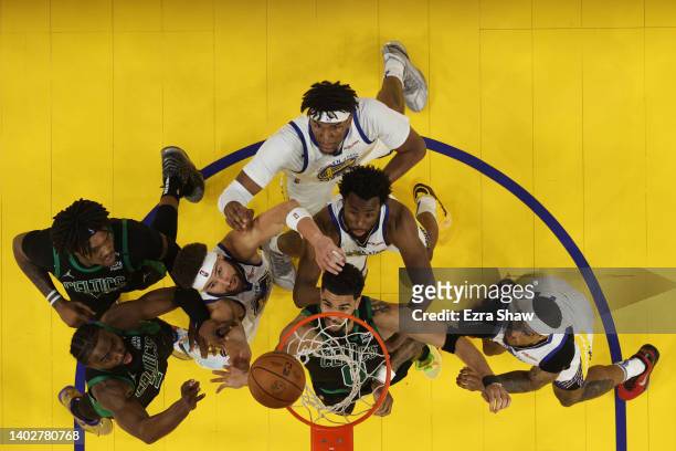 Jayson Tatum, Jaylen Brown and Robert Williams III of the Boston Celtics compete for the rebound against Klay Thompson, Kevon Looney, Andrew Wiggins...