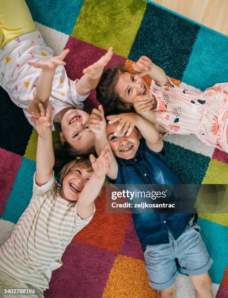 smiling teacher and little child talking and playing at preschool - nursery school stockfoto's en -beelden