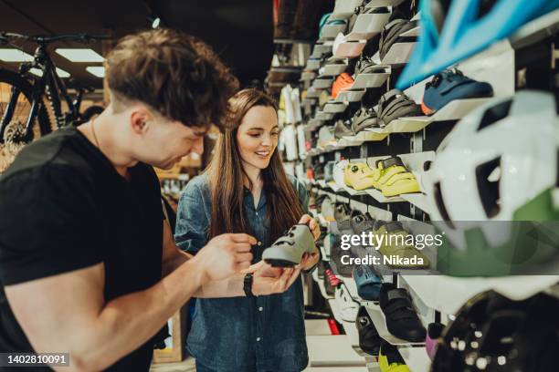 femme achetant une chaussure de vélo dans un magasin de vélos - magasin de sport photos et images de collection