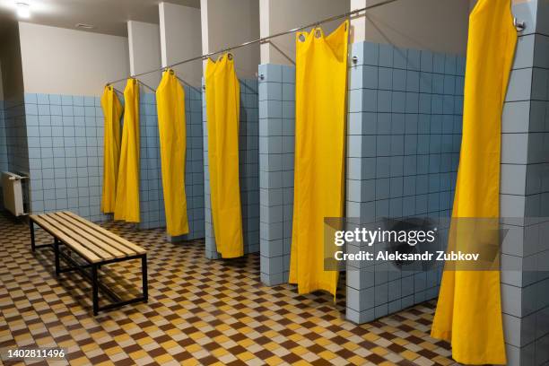 public shower room with shower cabins. a large, empty public shower room with bright walls. toilet and locker room of a swimming pool, sports club and fitness center, school, college, dorm or hostel. the concept of hygiene and healthy lifestyle. - hostel room stock-fotos und bilder