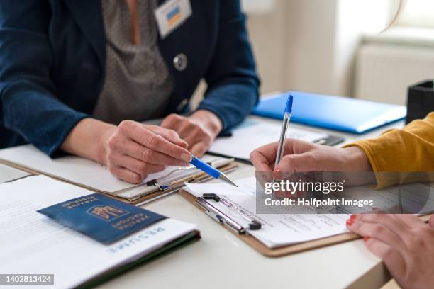 close-up of filling in paper form and ukrainian passport. - émigration et immigration photos et images de collection