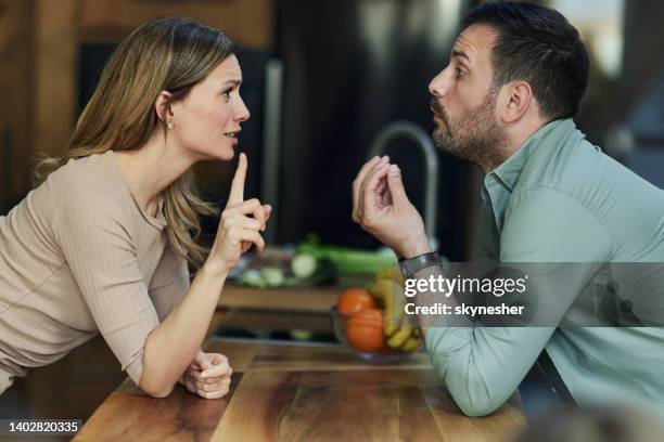 young couple having an argument at home. - petty stock pictures, royalty-free photos & images